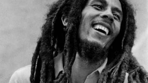Schwarz-Weiß-Portrait eines lachenden Bob Marleys mit langen Dreadlocks