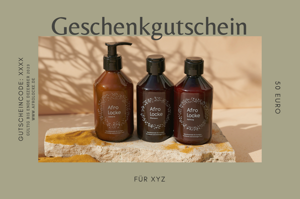 Afrolocke Geschenkgutschein mit drei Produkten auf einer Steinplatte